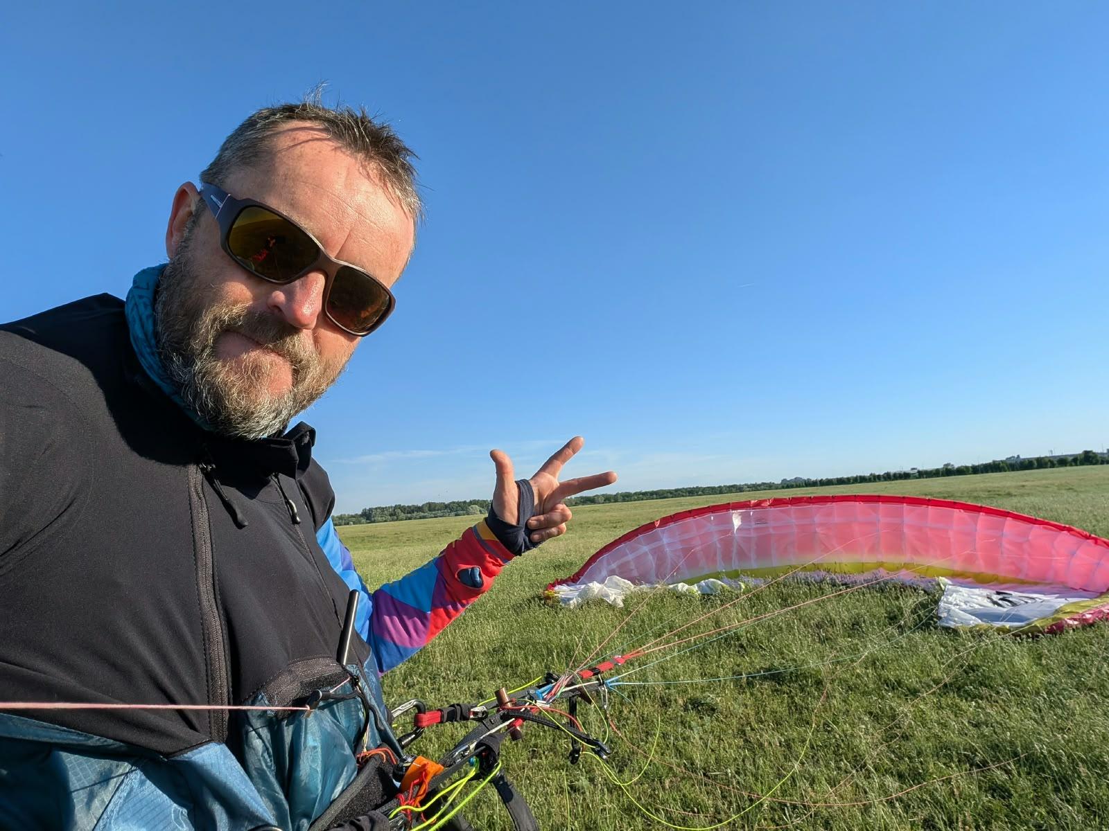 Botes, pilot tandem OneSky, lângă aripa întinsă pe câmp