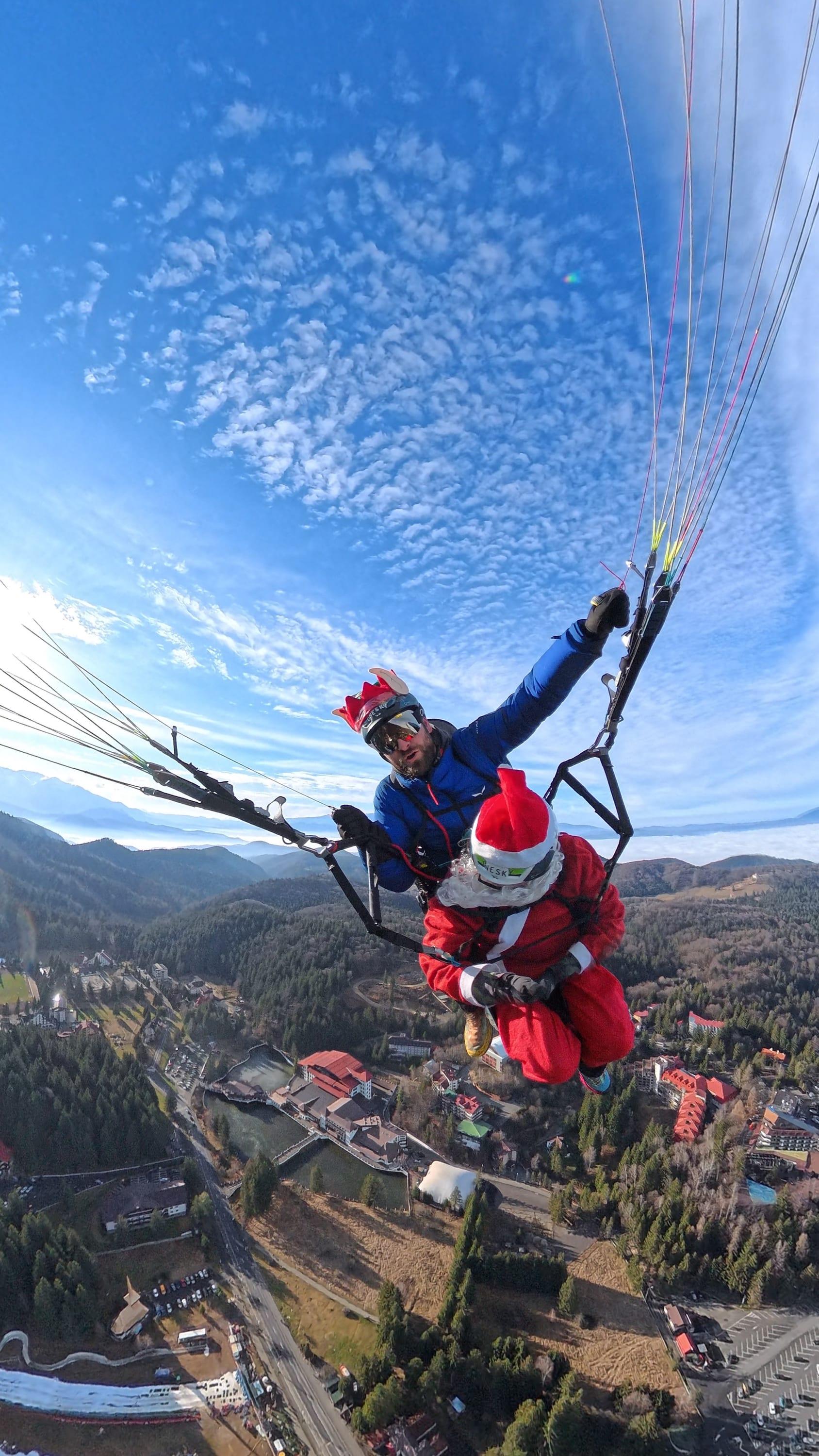 Moș Crăciun în zbor tandem deasupra stațiunii Poiana Brașov