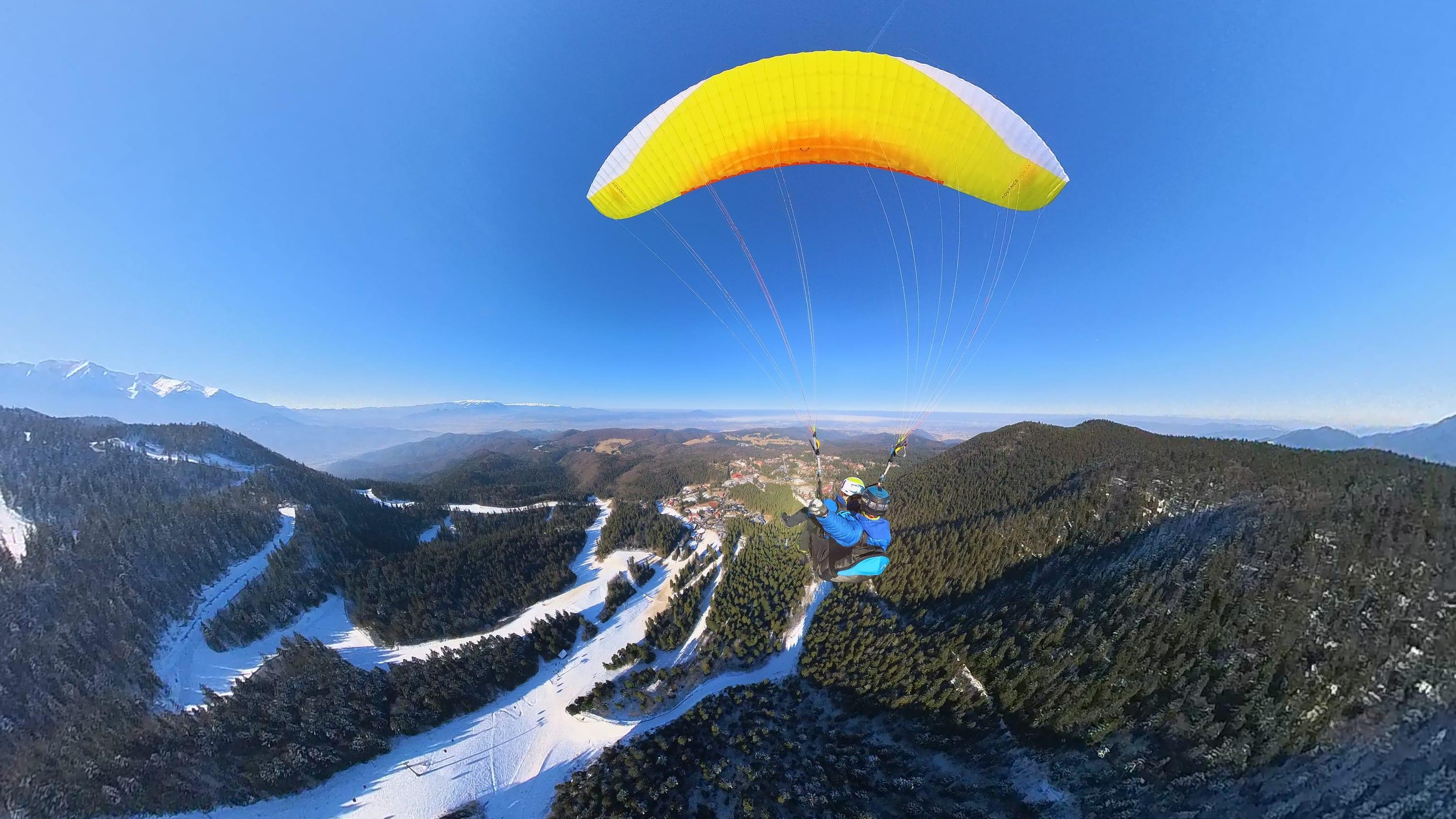 Panoramă largă de iarnă din zbor, deasupra Postăvarului și a văii