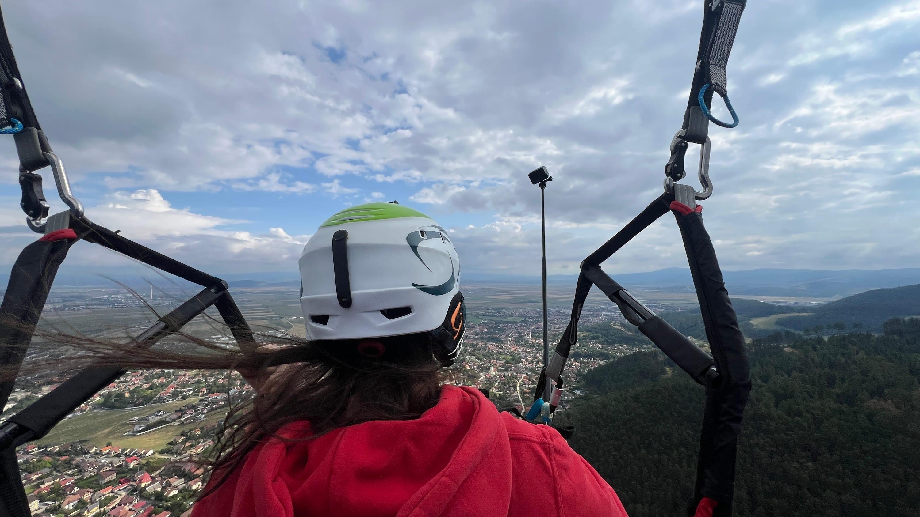 Perspectiva pasagerei în zbor, cu valea și orașul în față