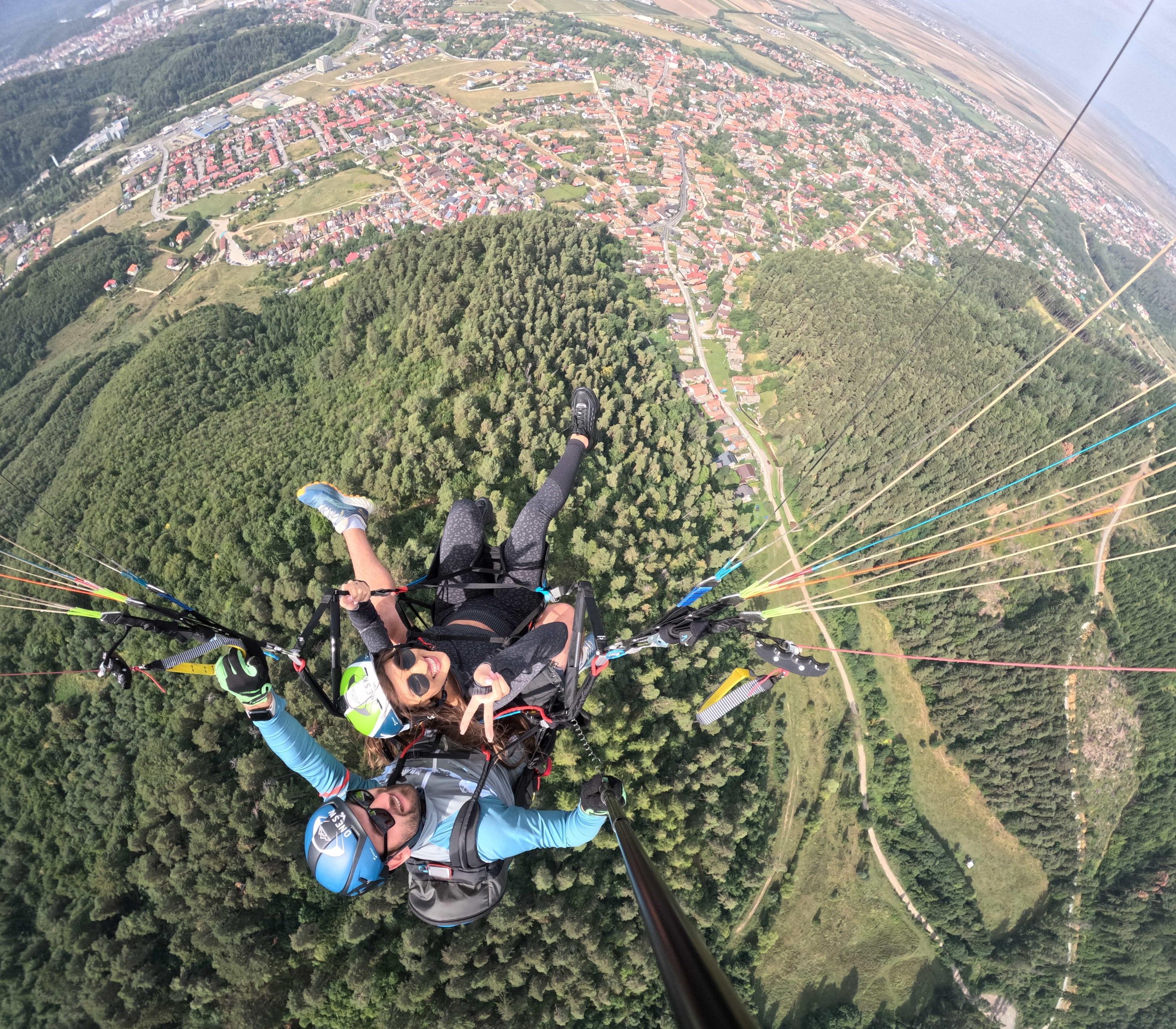 Tandem văzut de sus, deasupra pădurii verzi și a cartierelor Brașovului
